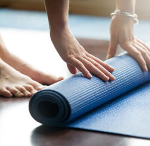 A woman folding mat after yoga