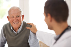 A old man smiling during consulting to doctor