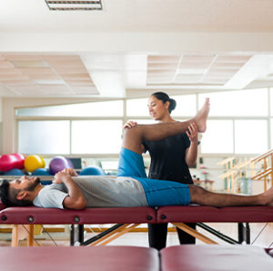 A beautiful physical therapist giving therapy session to patient