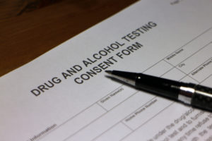 Someone filling out Drug and Alcohol Testing Consent Form