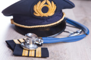 Close up of an airplane pilot equipment hat and epaluetes with doctor's stethoscope.