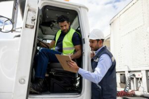Foreperson talking to a truckdriver while working at a distribution warehouse
