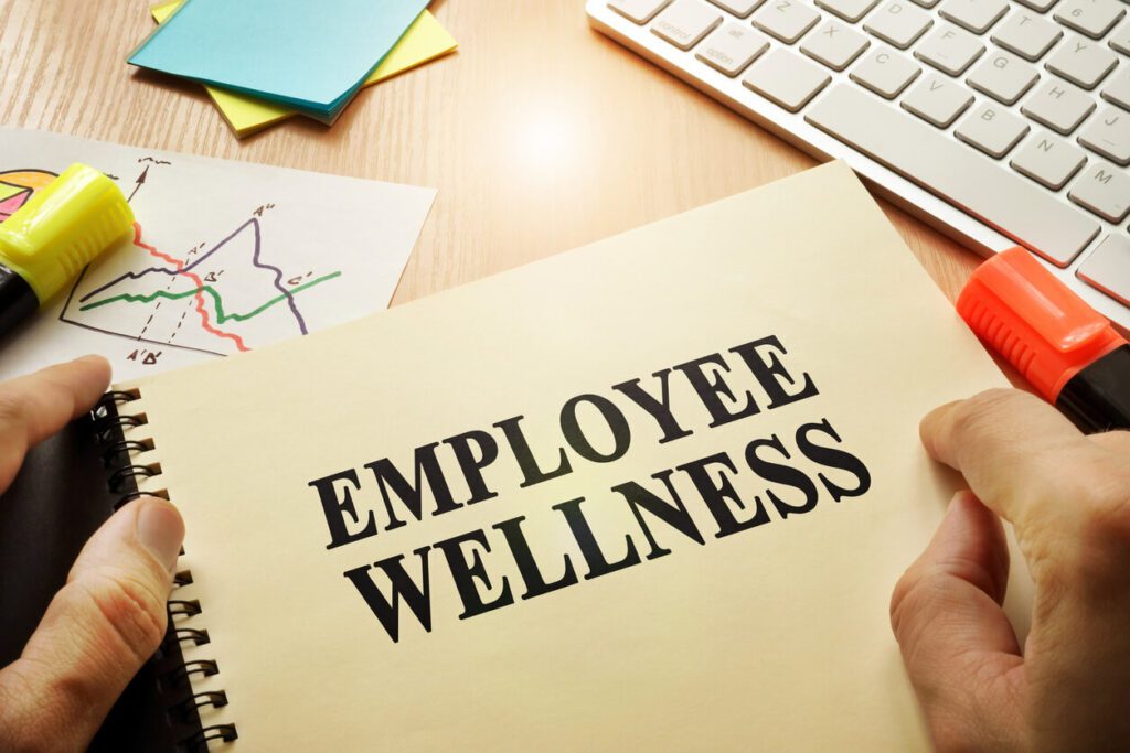 Hands holding documents with title Employee Wellness